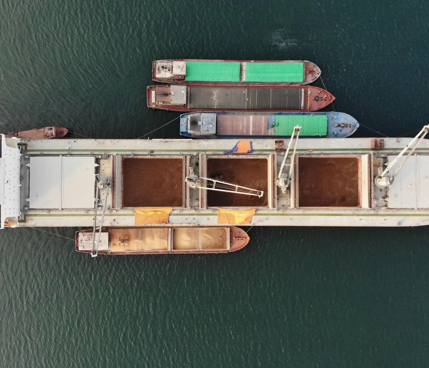 Geared bulker discharging into barges, seen from above